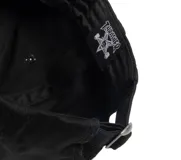 Gorra negra de béisbol con visera curva y logo de sol sonriente bordado en blanco en el frente.