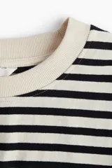 Remera cropped de algodón a rayas horizontales negras y blancas, de corte holgado con cuello redondo acanalado, hombros caídos y bajo recto.