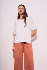 Remera blanca de algodón peinado con calce oversize y mangas cortas con detalle de calados.