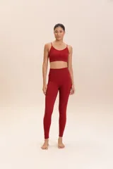 Conjunto deportivo color borgoña, compuesto por un top deportivo de tirantes finos y calzas de compresión media, sin costuras, de textura suave y alta transpirabilidad.