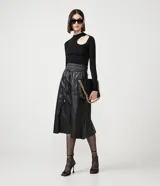 Blusa de punto negra con cuello redondo, manga larga y abertura circular en el hombro.