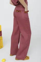 Pantalón de jean azul oscuro, de corte acampanado, con bolsillos delanteros con detalle de volados.