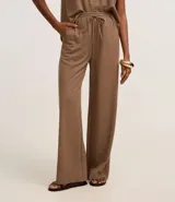 Pantalón recto color marrón claro, confeccionado en tejido orly con viscosa certificada, cintura elastizada con lazo ajustable.