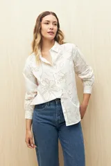 Camisa blanca de manga larga confeccionada en algodón liviano con calados florales. De corte clásico y botones frontales.