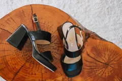 Sandalias de plataforma color borgoña, confeccionadas en charol. Tienen dos tiras anchas sobre el empeine, pulsera con hebilla al tobillo y taco cuadrado de 9 cm.