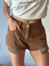 Short de jean negro con detalle de tela a cuadros en los laterales.