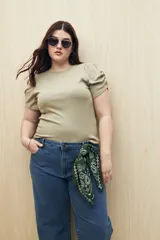 Top color verde oliva de tejido de punto acanalado, con cuello redondo y mangas cortas abullonadas.