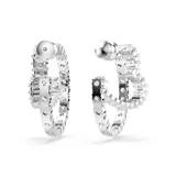 Aros tipo argolla con forma de corazón abierto, con circonitas Swarovski transparentes engarzadas en talla baguette y baño de rodio.