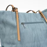 Bolso tipo tote de tela azul con textura, doble asa de cuero color camel y borla decorativa.