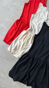 Minivestido negro con falda tableada, corte ajustado, sin mangas y cinturón ancho con tachas.