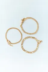 Set de tres pulseras doradas con diferentes diseños de eslabones.