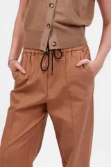 Pantalón Landscape color camel, de corte ancho y tiro alto, con cintura elastizada ajustable con cordón. Presenta bolsillos laterales y bordado al tono en el frente.