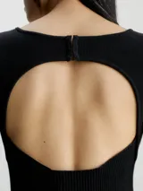 Vestido corto negro de punto de algodón orgánico, con cuello redondo, mangas largas y espalda descubierta con cierre de gancho.