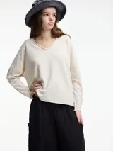 Sweater de punto color crema con escote en V y mangas largas.