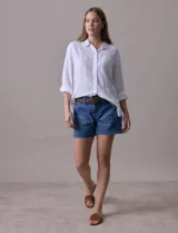 Camisa blanca de lino, marca Dash, con cuello con solapa, abertura central con botones, bolsillo aplicado en el pecho y mangas largas regulables con presilla y botón.