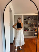 Pollera larga de broderie blanca, con cintura elastizada y corte escalonado.