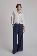 Camisa de lino color terracota, con cuello camisero, botones frontales y mangas amplias de tres cuartos.