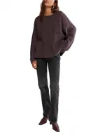 Camiseta blanca de punto waffle en algodón, con silueta relajada, hombros caídos, mangas largas, bolsillo frontal y escote amplio tipo barco.