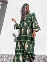 Vestido largo tipo túnica color verde con estampado beige, cuello en V y mangas largas.