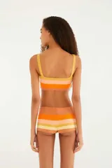 Top de bikini tejido a crochet con diseño a rayas horizontales en tonos amarillo, naranja y rosa.