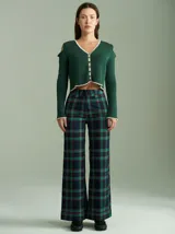 Saco de algodón verde con aberturas en hombros y codos, de corte entallado. Tiene cuello en V, botones pequeños y plaqueta de tejido puño color crudo.