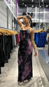 Vestido largo de fiesta con espalda descubierta y tiras finas. Presenta un estampado abstracto en tonos fucsia, violeta y negro.
