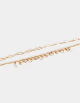 Pulsera dorada de doble cadena con dijes de perlas y strass.