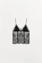 Top negro de encaje floral semitransparente con tirantes finos ajustables y escote en pico.