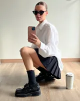 Mocasines negros de cuero vacuno con cordones, ojalillos metálicos y suela track.