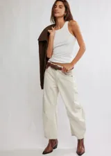 Pantalón de jean color crema, de corte relajado, piernas anchas y tiro medio. Tiene una silueta distinta y un largo hasta los tobillos.