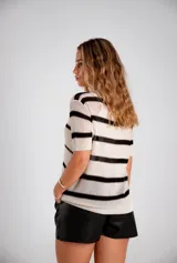 Remera de hilo tejida color crudo con rayas horizontales negras y mangas cortas.