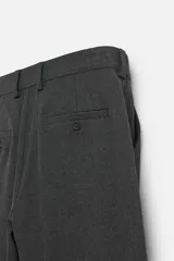 Pantalón slim fit negro confeccionado en tejido con elasticidad en ambas direcciones. Cuenta con bolsillos frontales y traseros de vivo con botón. Cierre frontal con cremallera y botón.