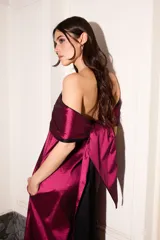 Vestido strapless de tafeta color magenta y negro, con corte holgado, largo midi, bolsillos laterales y pieza bicolor desmontable.