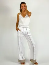 Pantalón gris de lino con corte palazzo y detalle de costuras amarillas en los laterales y en el ruedo.