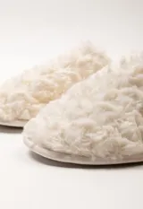 Pantufla de diseño peludo color blanco, con talón descubierto y plantilla acolchada.
