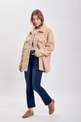 Sobrecamisa color beige de textura sherpa, con cuello clásico, cierre frontal con botones a tono, bolsillos de parche con solapa en el pecho y corte recto.