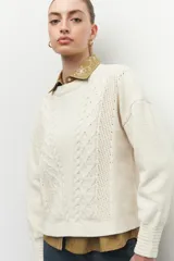 Sweater tramado de manga larga en color crudo, con puños elastizados y diseño texturizado.