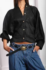Camisa de lino blanca con diseño original, más larga en la parte posterior y botones de guampa, con un tajo central en la espalda.