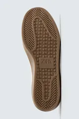 Zapatillas deportivas de hombre, de estilo retro, color blanco con puntera de gamuza color crema, detalle trasero en cuero negro y suela marrón.