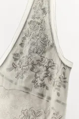 Vestido midi gris con estampado floral y abalorios, escote en V y tirantes anchos.