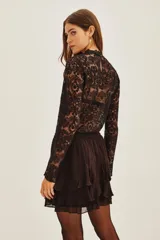 Falda corta negra con múltiples capas de volados en el ruedo.