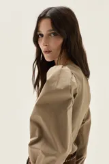 Top negro de calce al cuerpo con escote cuadrado amplio. Mangas largas abullonadas con puños elastizados.