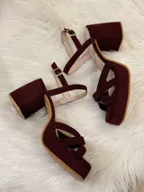 Sandalias de plataforma color vino con tiras cruzadas y tobillera con hebilla.