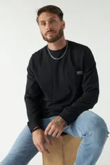 Remera color marrón de manga larga, con bolsillo en el pecho y logo de la marca en etiqueta sobre el bolsillo.