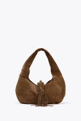 Bolso de hombro marrón de serraje con asa corta y flecos decorativos.