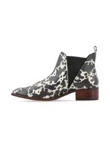 Botín Chelsea de cuero con estampado animal print en blanco y negro, elásticos laterales texturizados, punta semi-redondeada y taco bajo de madera.