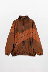 Campera estilo olímpica color marrón con efecto lavado y detalles en color ladrillo. Corte oversized, con elástico en la cintura y bolsillos al frente con cierre.