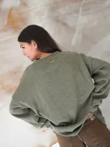 Sweater beige de hilo de algodón con cuello redondo y manga larga. Estampado con la bandera de Uruguay en el frente.