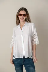 Camisa blanca lisa con aplique de guipiur en costados y mangas, de calce holgado.