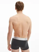 Pack de tres bóxers negros Calvin Klein de corte low rise, con cinturilla elástica gris con el logo de la marca en blanco.